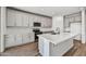 Modern kitchen features gray cabinets, stainless steel appliances, and an island with a sink at 37551 W Patterson St, Maricopa, AZ 85138