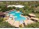 Aerial view of the community pool surrounded by trees, seating, and lounge area at 3935 E Rough Rider Rd # 1016, Phoenix, AZ 85050