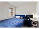 Well-lit bedroom with a blue bedspread, a window with blinds, and a gaming setup at 3935 E Rough Rider Rd # 1016, Phoenix, AZ 85050