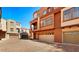 Exterior view of townhomes with brick driveways, garages and balconies on a sunny day at 3935 E Rough Rider Rd # 1016, Phoenix, AZ 85050
