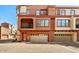 Exterior view of townhomes with balconies, garages, and red brick driveways under blue sky at 3935 E Rough Rider Rd # 1016, Phoenix, AZ 85050