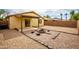 Spacious backyard with desert landscaping, a stylish fire pit, and a covered patio, ideal for entertaining guests at 44944 W Miramar Rd, Maricopa, AZ 85139