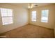 Bedroom with three large windows and neutral carpeting at 44944 W Miramar Rd, Maricopa, AZ 85139