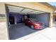 An attached garage with a parked car and painted walls at 44944 W Miramar Rd, Maricopa, AZ 85139