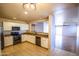 Bright kitchen with stainless steel appliances, white cabinetry, and an open layout, seamlessly connecting to the living area at 44944 W Miramar Rd, Maricopa, AZ 85139