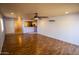 Inviting living room with hardwood flooring, a ceiling fan, and seamless access to the kitchen, perfect for Gathering gatherings at 44944 W Miramar Rd, Maricopa, AZ 85139