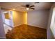 Open living room boasts a ceiling fan and hardwood floors with a pass-through to the kitchen at 44944 W Miramar Rd, Maricopa, AZ 85139