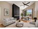 Bright living room features modern fireplace, vaulted ceilings, ceiling fan, and views of backyard at 4753 E Bighorn Ave, Phoenix, AZ 85044