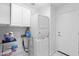 Functional laundry area with stacked washer/dryer unit, storage cabinets, and utility sink at 4976 S Sugarberry Ln, Gilbert, AZ 85298