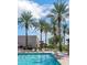 Inviting community pool with palm trees, lounge chairs and lush landscaping at 4976 S Sugarberry Ln, Gilbert, AZ 85298
