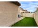 Backyard featuring artificial turf, brick pavers, and the exterior of a stucco home at 5253 E Hilton Ave, Mesa, AZ 85206