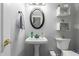Half bathroom with pedestal sink, decorative mirror, and neutral wall color at 5253 E Hilton Ave, Mesa, AZ 85206