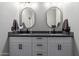 Modern bathroom with double sinks, black countertops, and white cabinets at 5253 E Hilton Ave, Mesa, AZ 85206