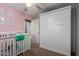Bedroom featuring a crib, changing table, closet, neutral walls, and carpet flooring at 5253 E Hilton Ave, Mesa, AZ 85206