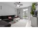 Cozy living room with a dark couch, brick accent wall, and sliding glass doors at 5253 E Hilton Ave, Mesa, AZ 85206