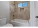 Modern bathroom featuring a bathtub with shower, tile surround, and a window for natural light at 5515 E Dale Ln, Cave Creek, AZ 85331