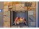 Close up of a stone fireplace featuring a herringbone firebox with burning logs, showcasing a warm and inviting ambiance at 5515 E Dale Ln, Cave Creek, AZ 85331
