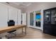 Bright office features a modern desk, sleek storage, wood-look tile floors and French doors to the outdoors at 5515 E Dale Ln, Cave Creek, AZ 85331