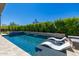 Inviting backyard pool with lush privacy hedging, stone accents, and sun loungers for relaxation at 5515 E Dale Ln, Cave Creek, AZ 85331