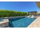 Inviting backyard pool with lush privacy hedging, waterfall features, and shaded sun loungers for relaxation at 5515 E Dale Ln, Cave Creek, AZ 85331