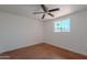 Bright bedroom featuring a ceiling fan and a window offering a view of palm trees at 556 N Hobson Plz, Mesa, AZ 85203