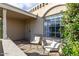 Inviting front porch featuring two wicker chairs, cushions, and a stylish tiled surface at 556 N Hobson Plz, Mesa, AZ 85203