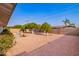Spacious backyard featuring mature trees, gravel landscaping, and a block wall for added privacy at 5633 E Colby St, Mesa, AZ 85205