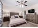 Relaxing bedroom with neutral décor, ceiling fan, dresser, and bedside tables with lamps at 5633 E Colby St, Mesa, AZ 85205