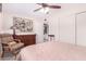 Cozy bedroom with carpet, ceiling fan, dresser, and accent chair with vintage artwork at 5633 E Colby St, Mesa, AZ 85205