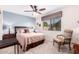 Stylish bedroom with a bright blue accent wall, ceiling fan, bedside tables, and patterned curtains at 5633 E Colby St, Mesa, AZ 85205
