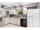 Bright kitchen features white cabinets, granite countertops and stainless-steel dishwasher and refrigerator at 5633 E Colby St, Mesa, AZ 85205