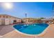 Community swimming pool featuring sun loungers, shaded tables, and a clear blue pool under a sunny sky at 5633 E Colby St, Mesa, AZ 85205