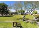 Large community park with mature trees, green grass, and a bench for relaxation at 5810 E Nora St, Mesa, AZ 85215