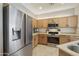 Modern kitchen with stainless steel appliances, tile backsplash, and wooden cabinets at 5810 E Nora St, Mesa, AZ 85215