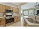 Functional kitchen with wood cabinets, stainless steel appliances, and easy access to the living area at 5810 E Nora St, Mesa, AZ 85215