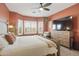 Primary bedroom with carpet features two windows, a large TV and a King size bed at 5810 E Nora St, Mesa, AZ 85215
