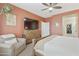 Cozy primary bedroom features light walls, a large TV, and decorative wall hangings at 5810 E Nora St, Mesa, AZ 85215