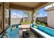 Covered patio with outdoor seating, garden decor, and views of the manicured backyard at 5810 E Nora St, Mesa, AZ 85215