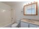 Clean, all-white bathroom features a tub and shower and a vanity with sink at 719 E Broadway Ave, Apache Junction, AZ 85119