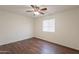 Bedroom featuring dark vinyl wood floors, a ceiling fan, and natural light from the window at 719 E Broadway Ave, Apache Junction, AZ 85119