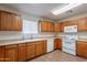 Well-lit kitchen features ample counter space, wooden cabinets, and white appliances at 719 E Broadway Ave, Apache Junction, AZ 85119