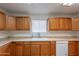 Bright kitchen featuring wood cabinets, white appliances, and natural light from window at 719 E Broadway Ave, Apache Junction, AZ 85119