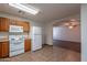 Bright kitchen with white appliances and wooden cabinets, leads to living space at 719 E Broadway Ave, Apache Junction, AZ 85119