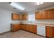 Functional kitchen with ample wood cabinets, tile flooring, and essential appliances for meal preparation at 719 E Broadway Ave, Apache Junction, AZ 85119