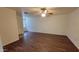 Inviting living room boasts wood floors, a ceiling fan, and natural light from the entry door at 719 E Broadway Ave, Apache Junction, AZ 85119