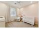 Inviting bedroom features soft, pastel colors, a crib and comfortable upholstered chair at 732 W Flintlock Way, Chandler, AZ 85286