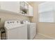 Convenient laundry room with washer, dryer, and storage cabinets for organization at 732 W Flintlock Way, Chandler, AZ 85286