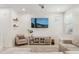 Bright living room with a TV, floating shelves, a blush colored armchair, and a grey sofa at 732 W Flintlock Way, Chandler, AZ 85286