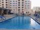 Outdoor community pool surrounded by lounge chairs and tables, offering a relaxing and social gathering space for residents at 7970 E Camelback Rd # 209, Scottsdale, AZ 85251