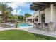 Expansive backyard featuring a pool, swim-up bar, lounge seating, and lush green turf at 8229 N Ridgeview Dr, Paradise Valley, AZ 85253